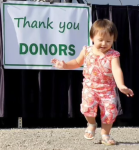 On opening day at Owen's Playground, a little girl danced in front of the thank you note on the speakers' platform